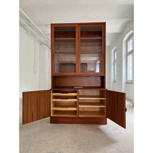 This beautiful teak display cabinet is an outstanding example of masterful Danish design from the mid-century era,...