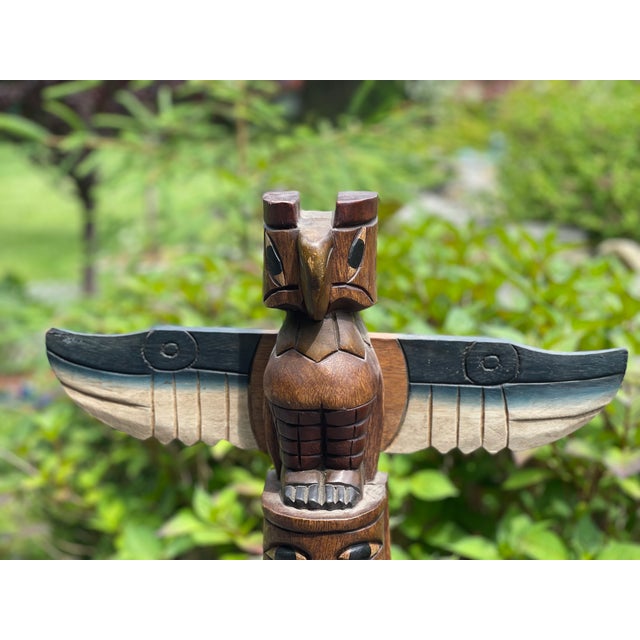 This vintage pole meticulously hand-carved and painted, showcasing the artistic skill and cultural knowledge of the...