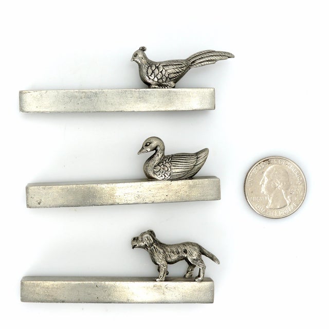 A set of three French pewter knife rests in the designs of a duck, a dog, and a pheasant that will keep your knives from...