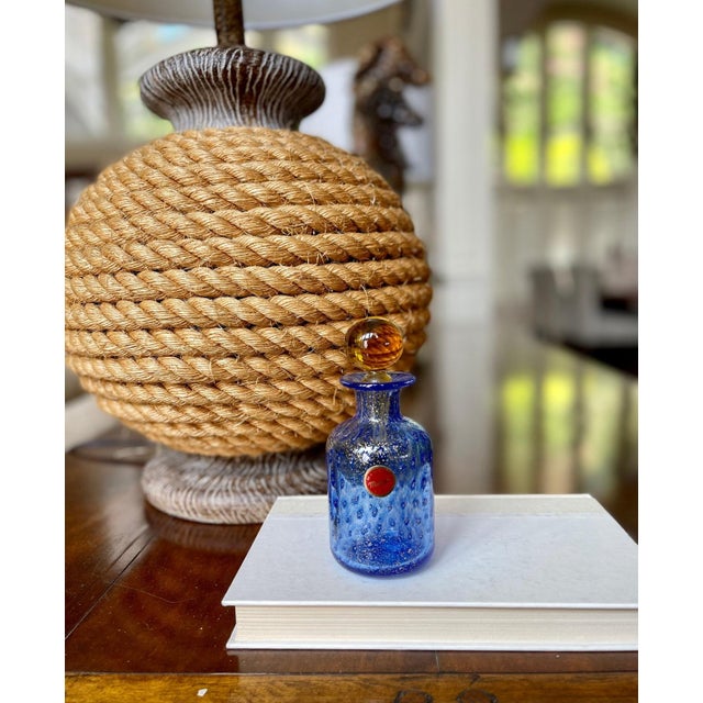 Beautiful piece of Murano glass, shaped as a small decanter, presented in a vivid blue with tiny gold flakes through...