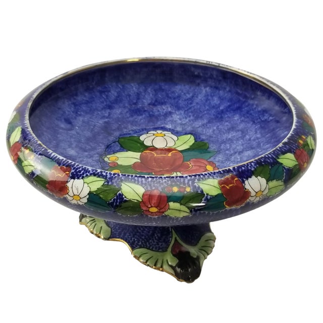 A lustrous relic of the 1920s, this pedestal dish carries the splendor of English craftsmanship. The deep cobalt ground is...