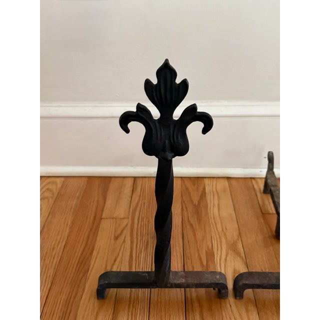 Petite French fleur-de-lis andirons made of cast iron. Circa mid 20th century. The fleur-de-lis is one of the most...