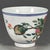 A charming Chinese porcelain tea cup. The exterior is finely hand-painted in vibrant Famille Rose enamels, featuring a...