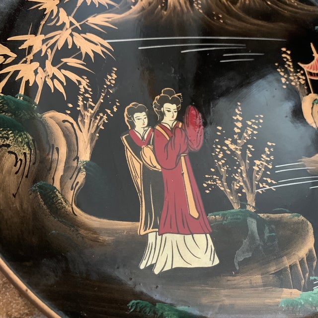 Decorative plate with an Asian scene. Black with faded gold and a little red coloring.