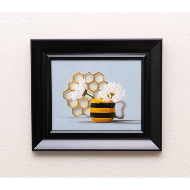 In "Blooming Days," a vibrant yellow and black striped mug cradles delicate white daisies, creating a striking contrast...