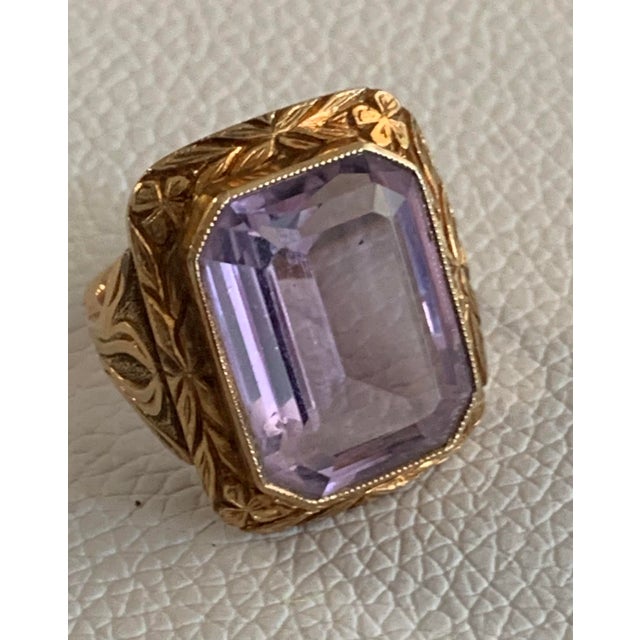 This antique ring boasts a stunningly faceted, deep lavender amethyst set in a complex 14K gold band. The craftsmanship is...