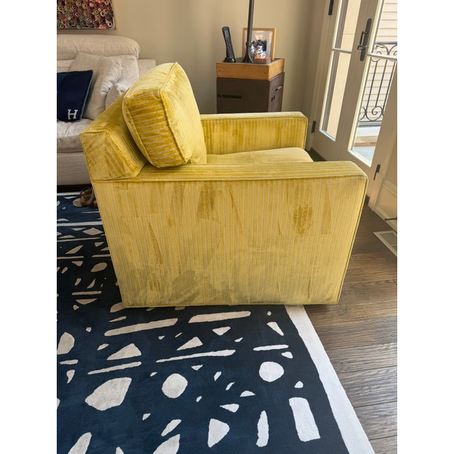 This Kravet swivel armchair features a classic box‑arm silhouette paired with richly textured mustard‑gold striped...