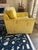 This Kravet swivel armchair features a classic box‑arm silhouette paired with richly textured mustard‑gold striped...
