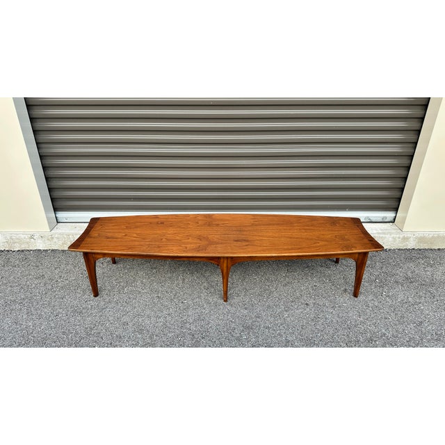 Hang ten with this beautiful mid century surfboard style coffee table. This piece features beautiful walnut grain with...
