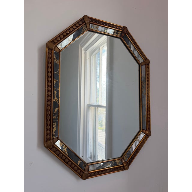 Vintage 1970’s Hollywood Regency octagonal mirror featuring a wooden frame with black and gold marble paneling