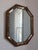 Vintage 1970’s Hollywood Regency octagonal mirror featuring a wooden frame with black and gold marble paneling