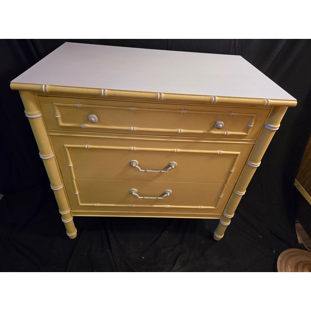 Attributed to Thomasville Allegro yellow faux bamboo 3 drawer dresser with white laminate top. This piece is part of a set...