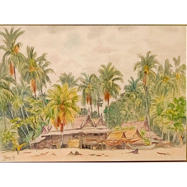A Southeast Asian watercolor on silk, circa 1920. The scene depicts several houses on a beach with boats on the sand.