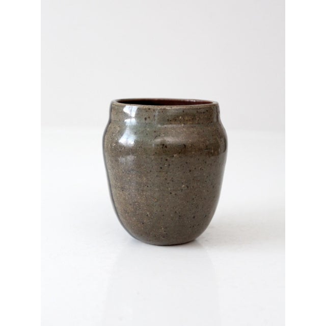 This vintage studio pottery mug is signed by the artist and showcases a striking earthy glaze in taupe, black, and maroon...