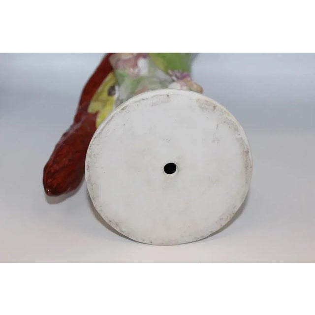 Porcelain parrot in the taste of Meissen, represented on a tree trunk, polychrome decor in natural, brand in blue with...