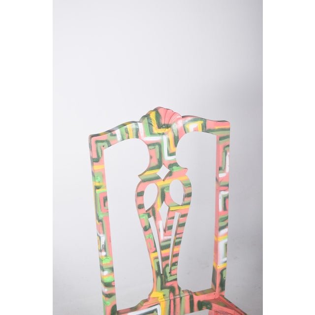 Painted dining chair. With a classic cut-out backrest, reinterpreted with a vibrant contemporary painting. The piece...
