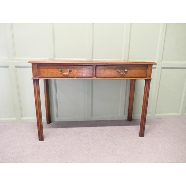 An Elegant 2 Drawer Writing Table or Reception Desk The Desk stands on elegant reeded legs and has a moulded edge around...