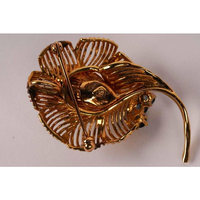 Introducing the Vintage Fourteen Karat Yellow Gold Diamonds and Sapphires Floral Brooch Pendant, an exquisite piece of...