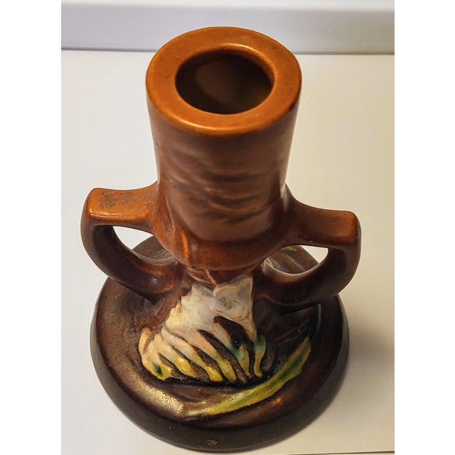 This is a vintage Roseville Freesia candle holder made of stoneware. It features a colorful tangerine color and a unique...