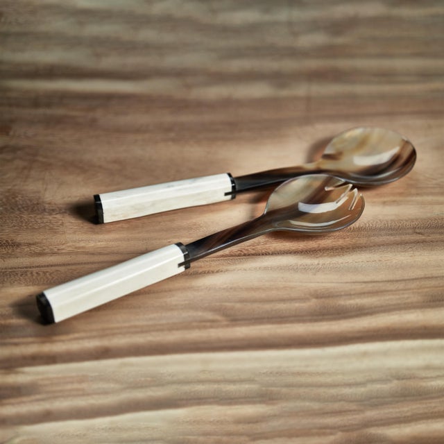 Beautifully crafted horn salad servers, each utensil features a simple shape with a finish that accentuates the horn's...