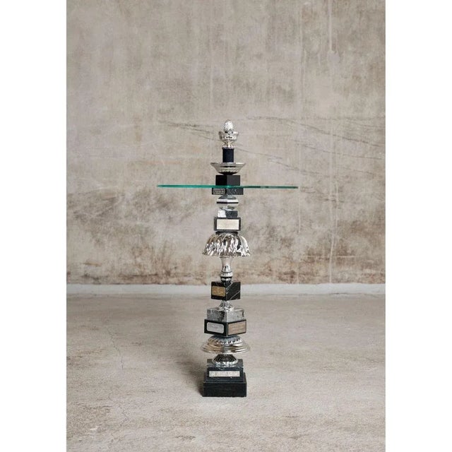 The silver pine cone table by Flétta Dimensions: D40 x H76 cm Materials: Black/silver/grey marble, glass. Trophy is a...
