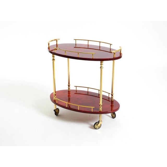 Rare 1960s Aldo Tura serving bar cart crafted from wood, clad in cherry-red goatskin and finished with a thick, clear...