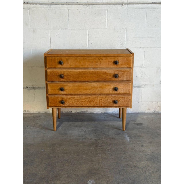 This small oak dresser pairs a compact upright case with four evenly stacked drawers. Raised side edges frame the top,...