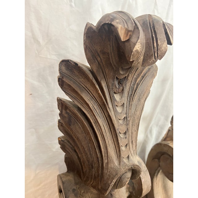 A pair of antique carved wooden corbels with acanthus leaf and scroll motifs that measure 34” tall x 8” deep and 7” wide....