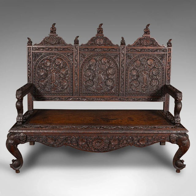 This is a large antique carved veranda bench. A Ceylonese, solid teak 3 seat ornate seat, dating to the Victorian period,...