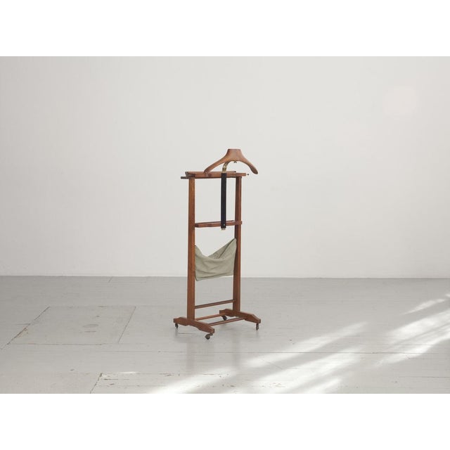 A valet stand from the 50s or 60s made of beech wood with castors. Made in Italy.