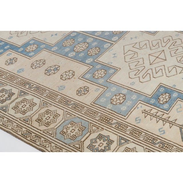 This is a vintage Turkish Oushak rug from the Mid 20th Century. The piece was hand-knotted.