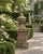A substantial two-piece Neoclassical garden finial ornament on pedestal crafted out of beautifully weathered cast stone....