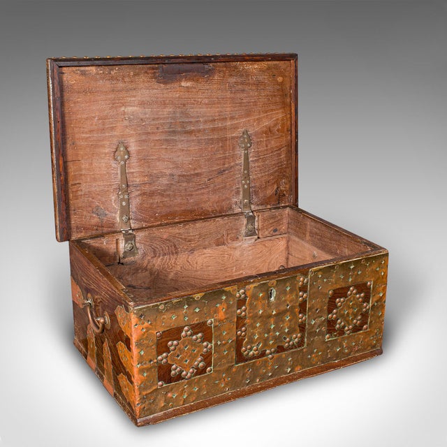 This is a small antique Zanzibar chest. An East African travel trunk in solid teak and brass, dating to the early...