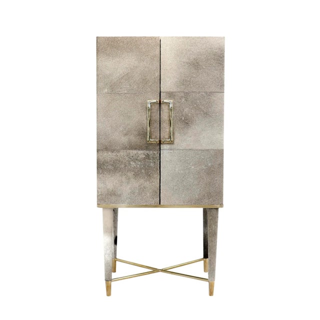 A sophisticated blend of natural texture and modern elegance, this bar cabinet is upholstered in richcowhide accented with...