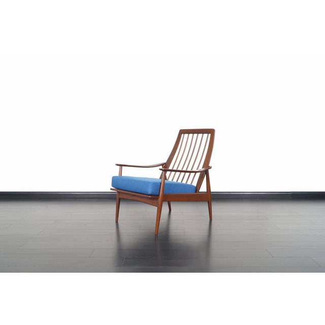 This striking mid-century modern walnut lounge chair, crafted in the United States during the 1950s, captures the...