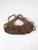 A vintage woven wall basket crafted from natural vine around a sculptural branch frame, with an open top and irregular...