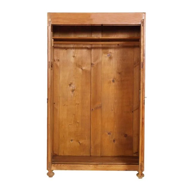 This is a Tyrolean country cupboard wardrobe in solid larch wood from the early 20th-century.