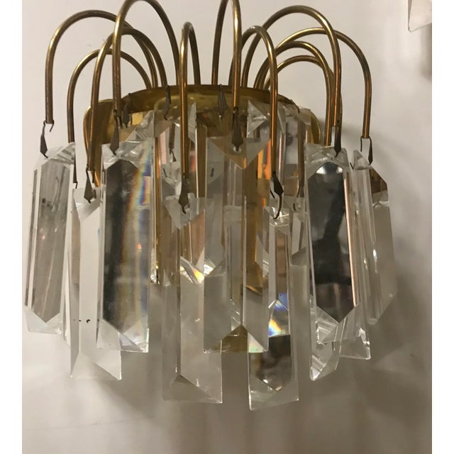 This pair of crystal prism sconces with brass frames feature E27 bulb sockets. European Plug (up to 250V).The wiring of...