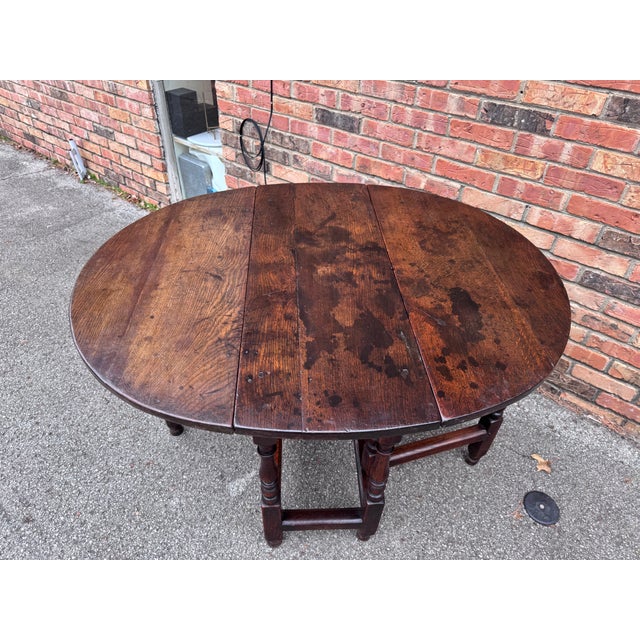 This finely crafted antique gateleg table is constructed of solid English oak with a rich, deep patina developed over...