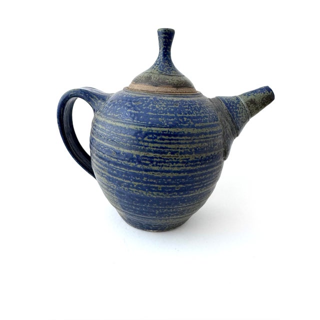 Here is a vintage blue stoneware teapot. This pottery teapot stands 7 3/4 inches tall and has a beautifully unique lid....