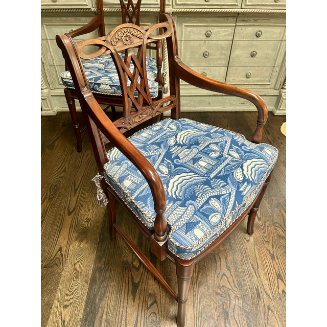 A handsome pair of Regency-style mahogany armchairs, featuring gracefully scrolled arms, tapered legs, and pierced splat...