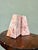 A sculptural pair of solid pink marble bookends in a clean wedge form, hewn from richly veined rose marble with sweeping...