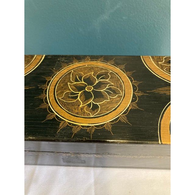 This vintage black wooden trinket box is hand painted with refined gold floral medallions, offering classic decorative...