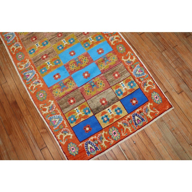 A pair of mid-20th century Turkish Anatolian rugs in bright intense colors. A multi-color repetitive box design surrounded...