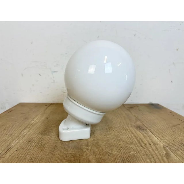 Vintage industrial wall light made in former Czechoslovakia during the 1960s.It features a white porcelain wall mounting...