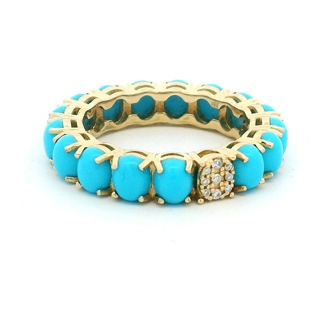 A beautifully crafted eternity band set in 14 karat yellow gold and composed of sixteen vivid Persian turquoise cabochons....