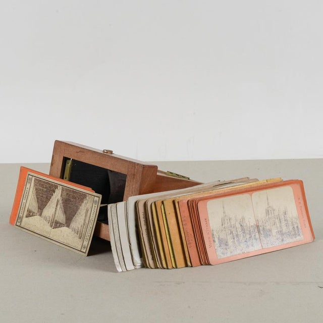 Vintage binocular photographic viewer with a series of photographs. This is a pocket stereoscope consisting of a small box...