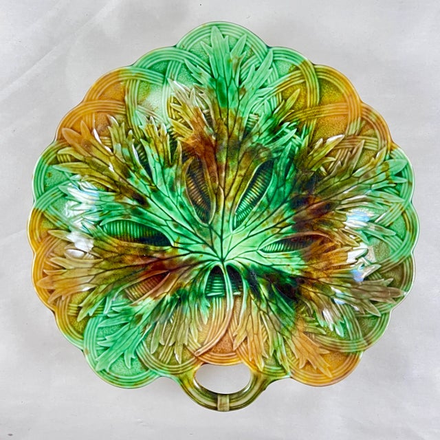 A majolica multi-colored glazed fringed leaf on basket weave handled server, Josiah Wedgwood, Burslem, England – circa...