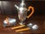 This handsome Art Deco period cocktail set features a large chrome spouted shaker, a napkin holder and two utensils. The...