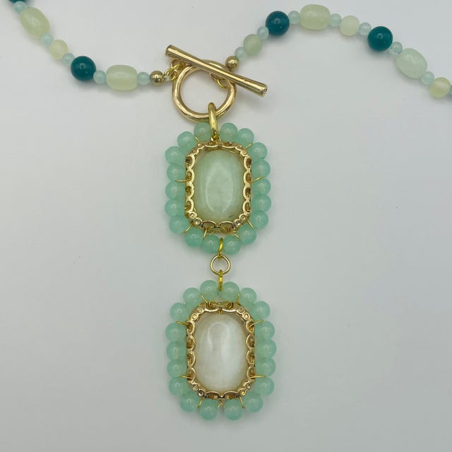 Green gemstone beaded strand, scrolling gold tone accents, front toggle closure. Substantial light green & white jade oval...